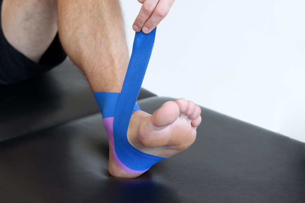 Kinesiology,Taping,Treatment,With,Blue,Tape,On,Male,Patient,Injured